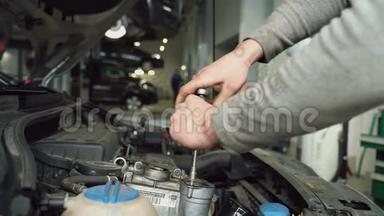 汽车机械师拧<strong>开机</strong>油填料的盖子。